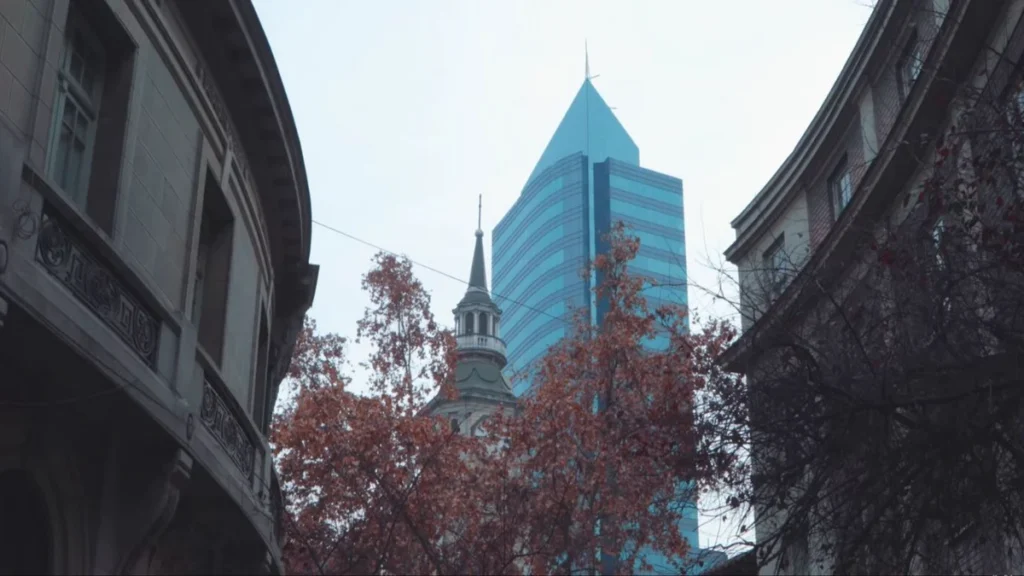 Vista de edifícios modernos e antigos em Santiago com céu nublado.