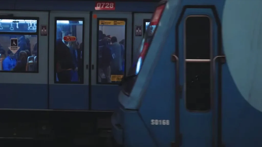 Trem do metrô de Santiago passando por uma estação movimentada.