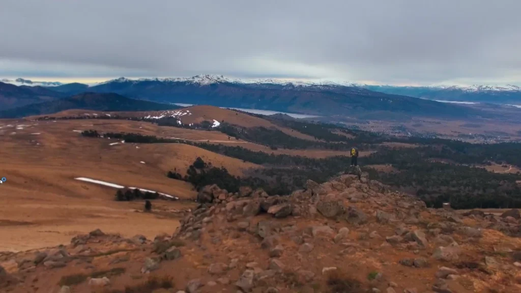 Vista panorâmica da Patagônia com montanhas e um explorador.