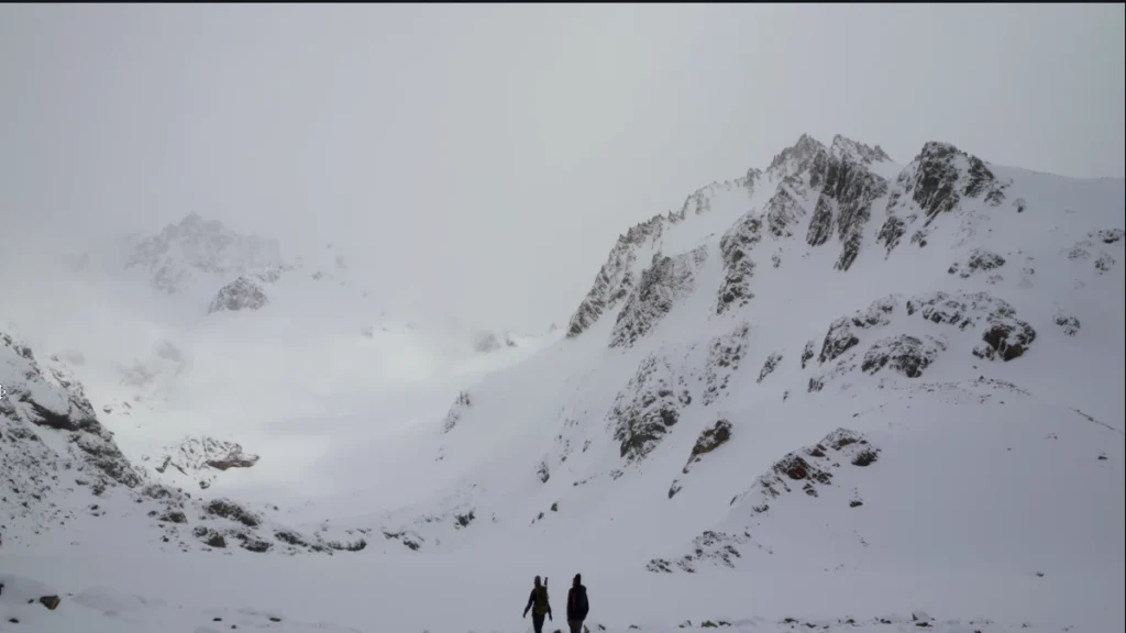 Caminhantes em um terreno coberto de neve nas montanhas da Patagônia