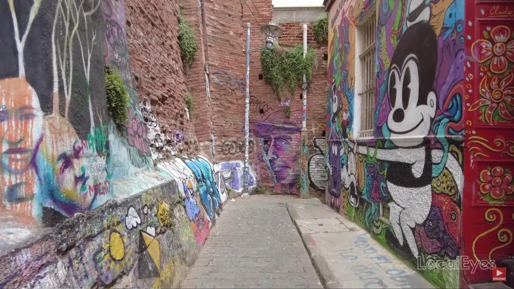 Escadaria artística em Valparaíso com murais coloridos nas paredes laterais