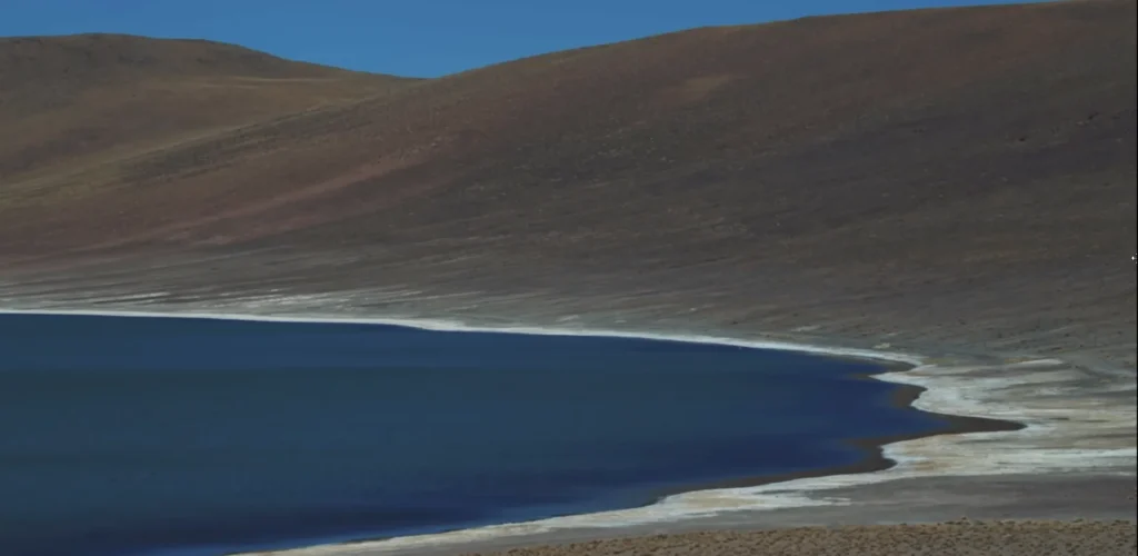 Lagoa no deserto com montanhas ao fundo