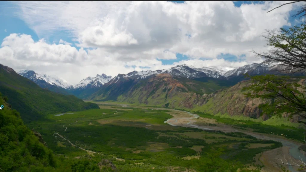 Vista panorâmica da paisagem da Patagônia com vales verdes e montanhas cobertas de neve