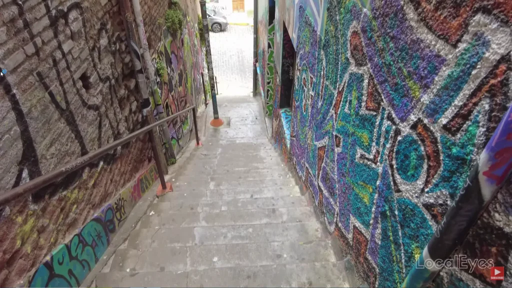 Passagem estreita entre edifícios em Valparaíso com grafites nas paredes