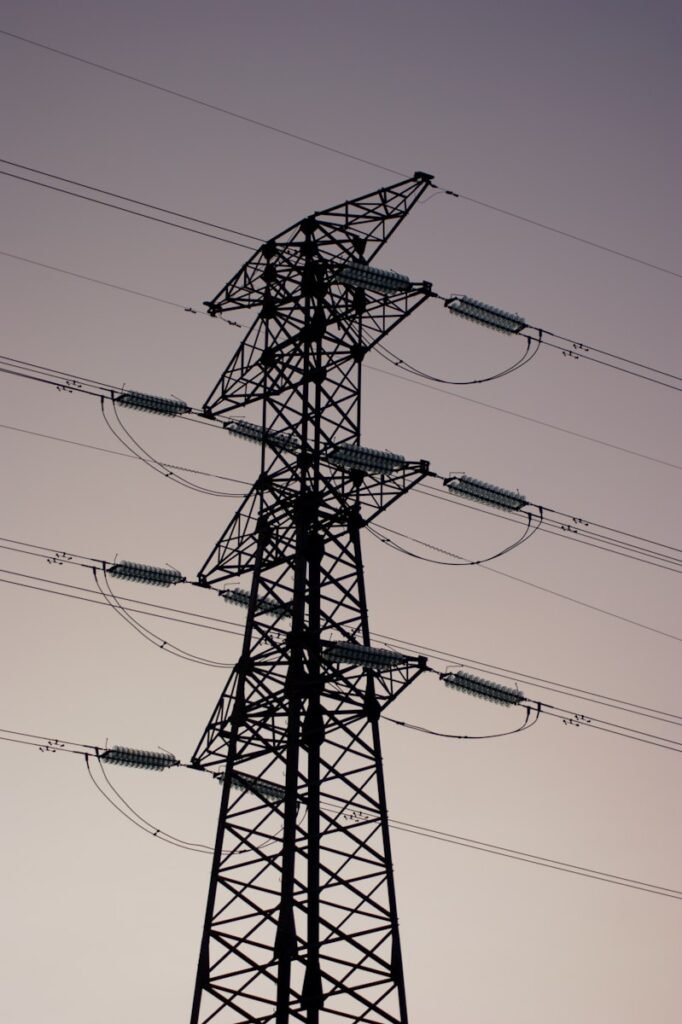 uma torre alta com muitas linhas de energia acima dela