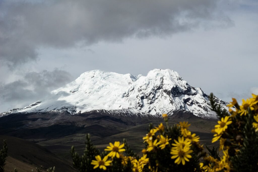 montanha coberta de neve sob céu nublado durante o dia