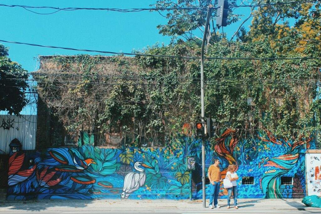 mulher de camisa azul e calça branca caminhando na rua durante o dia