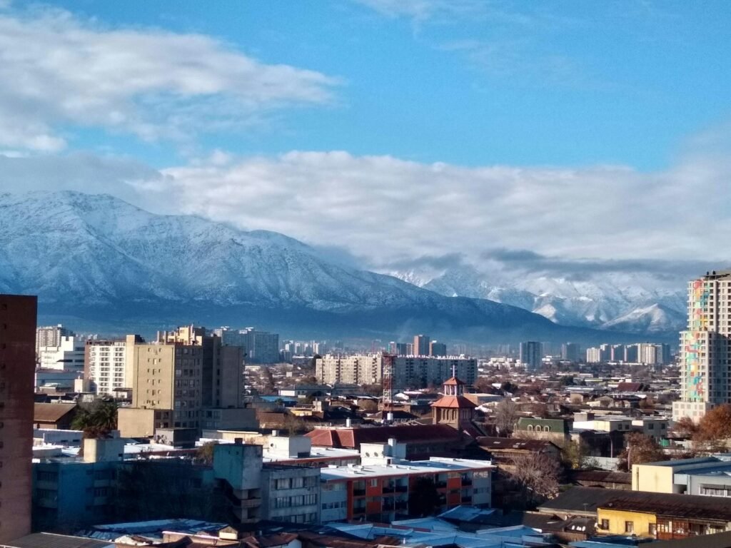cidade com edifícios altos perto da montanha sob nuvens brancas durante o dia