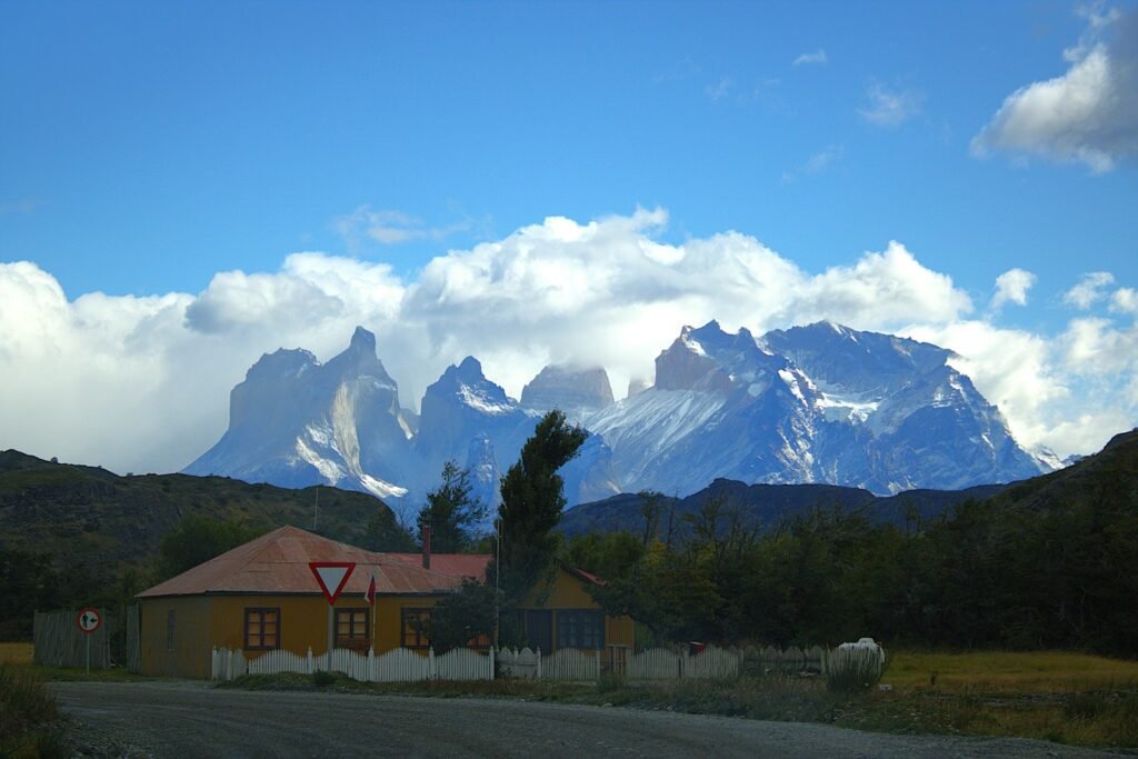 Uma estrada com uma casa e montanhas ao fundo