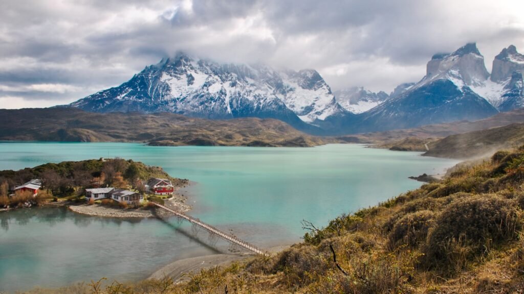 uma pequena ilha no meio de um lago com montanhas ao fundo