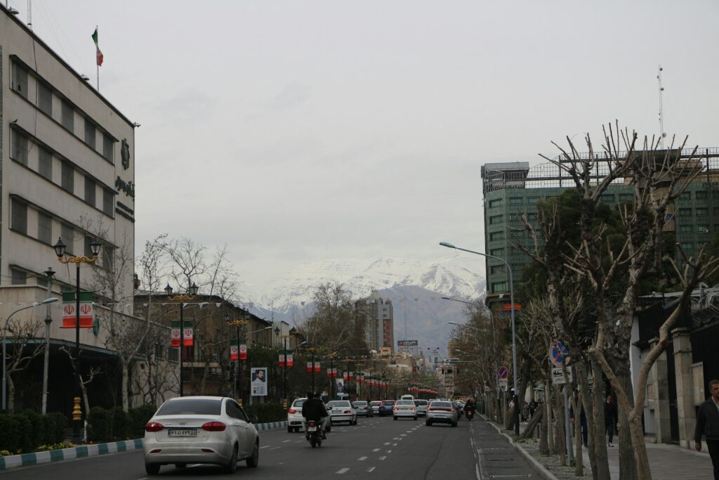 a city street filled with lots of traffic next to tall buildings