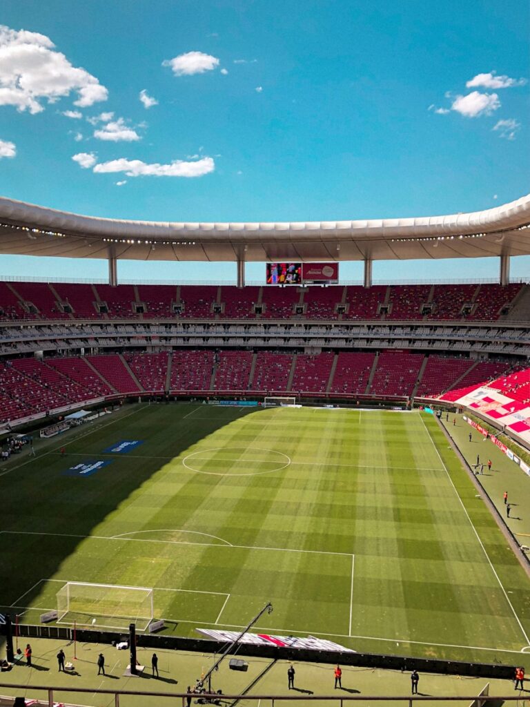 estádio de futebol verde e marrom sob céu azul durante o dia