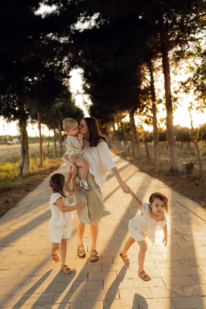 Mãe com três filhos caminhando em uma trilha