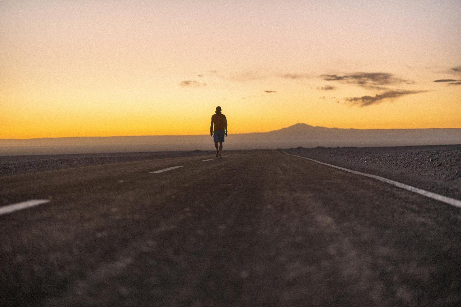 lone traveler walking at sunset in atacama desert