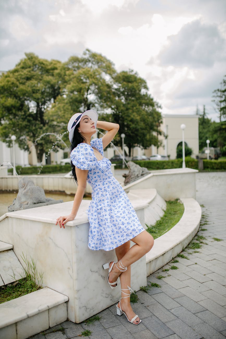 mulher estilosa posando perto de uma fonte em um jardim de verão