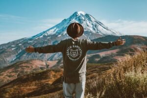 lonely traveller in hat admiring distant mountain