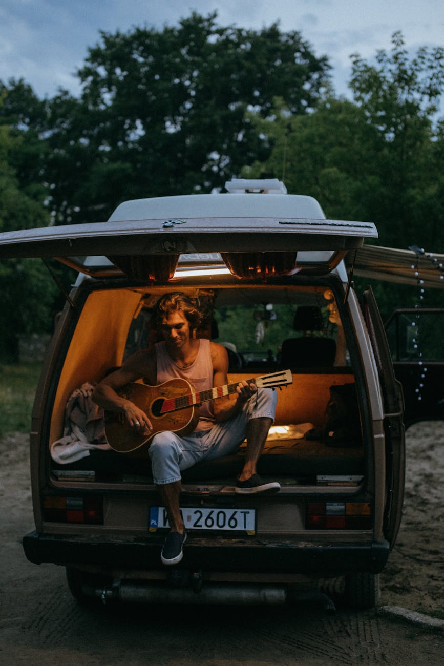 homem de jaqueta laranja sentado em carro preto