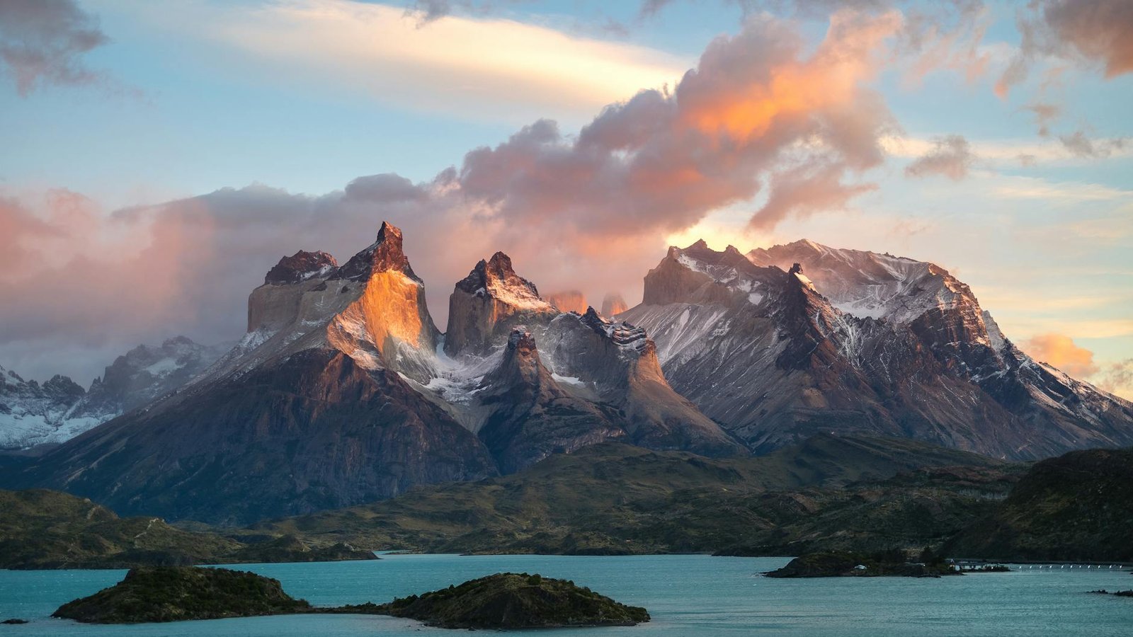 clouds covering snowcapped mountain peaks at sunset