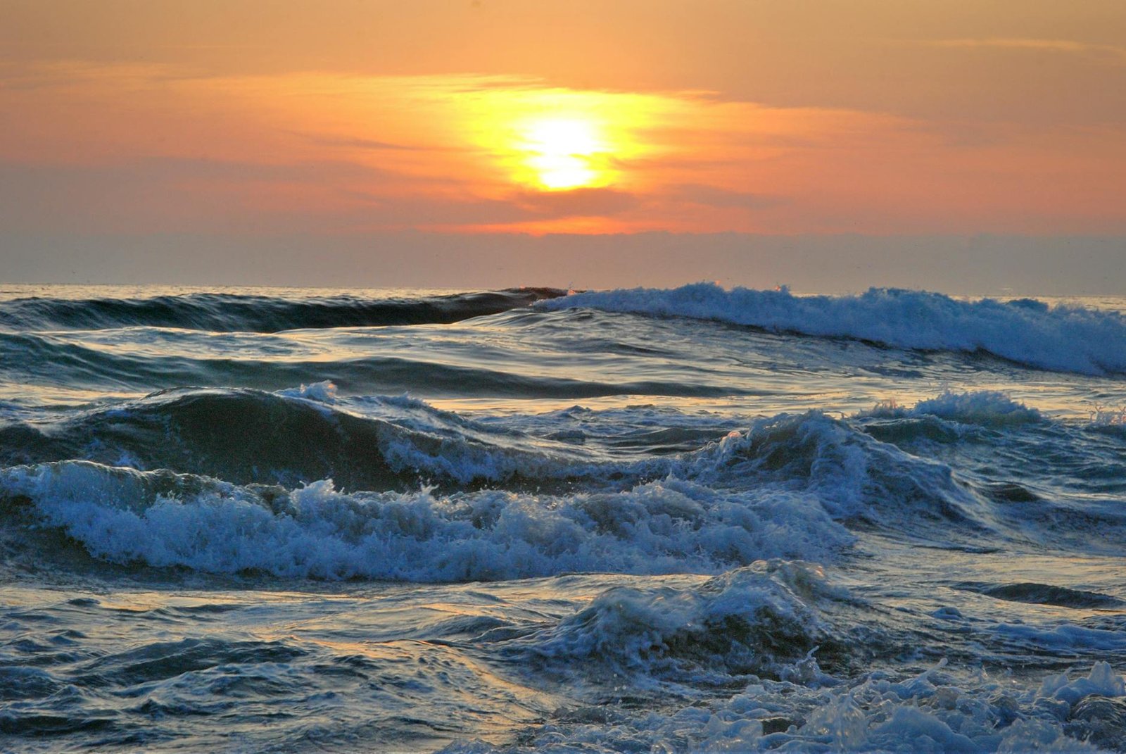 água do oceano durante o pôr do sol amarelo