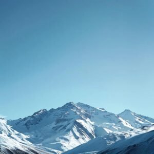 uma vista impressionante das majestosas montanhas dos andes no chile, cobertas por uma camada espessa de neve brilhante sob um céu azul claro, transmitindo a pureza e a beleza isolada do inverno chileno.