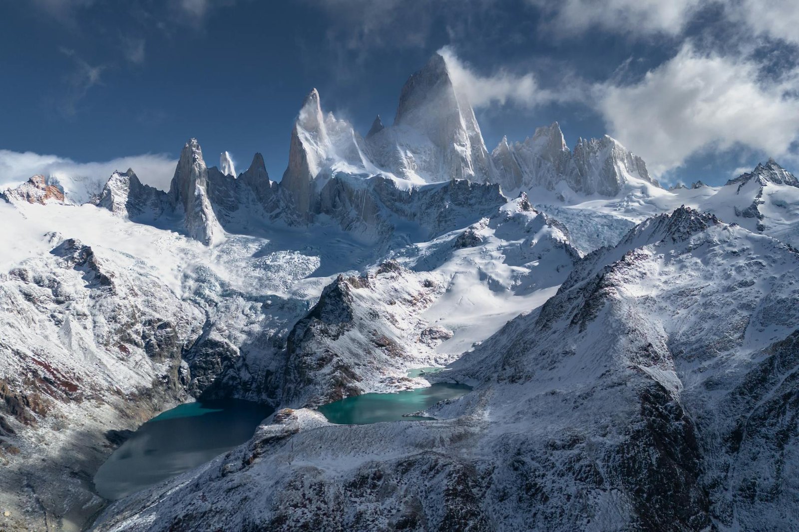 a vista de uma cadeia de montanhas nevadas com um lago