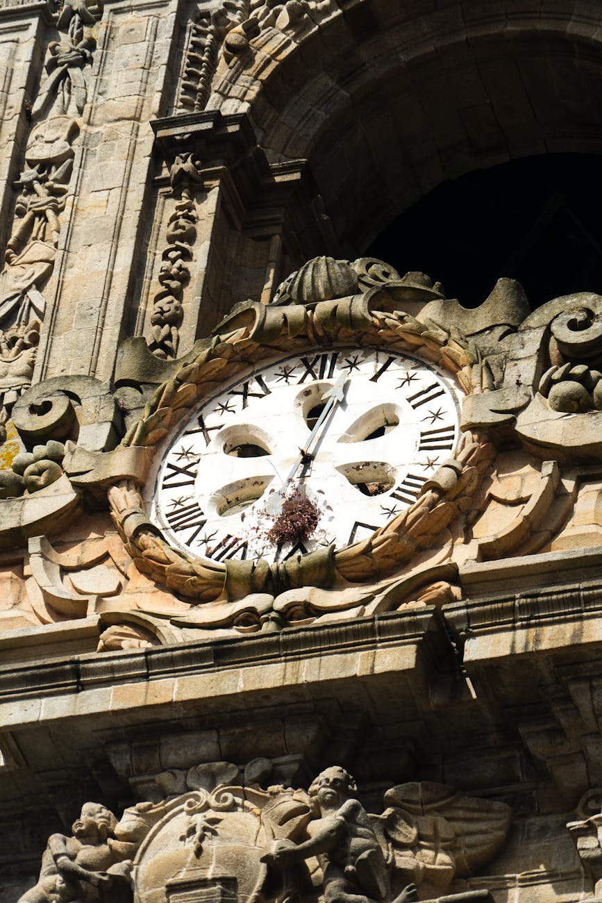 relógio de pedra ornamentado na fachada de um edifício histórico
