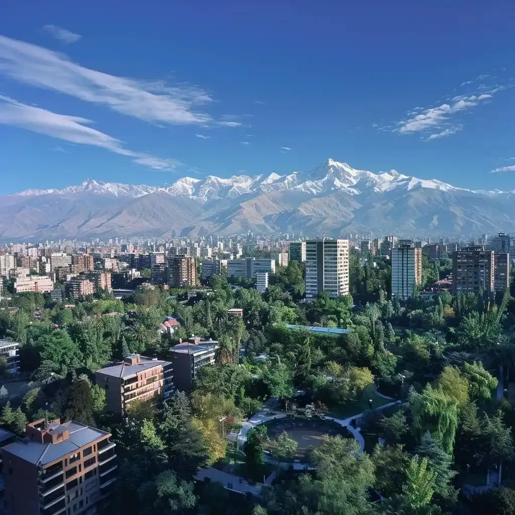 uma vista panorâmica da vibrante cidade de santiago, chile, com o fundo das imponentes montanhas dos andes sob um céu azul claro e ensolarado, enquanto à frente se destaca um parque urbano bem cuidado que sugere a preparação para uma viagem prática e eficiente.