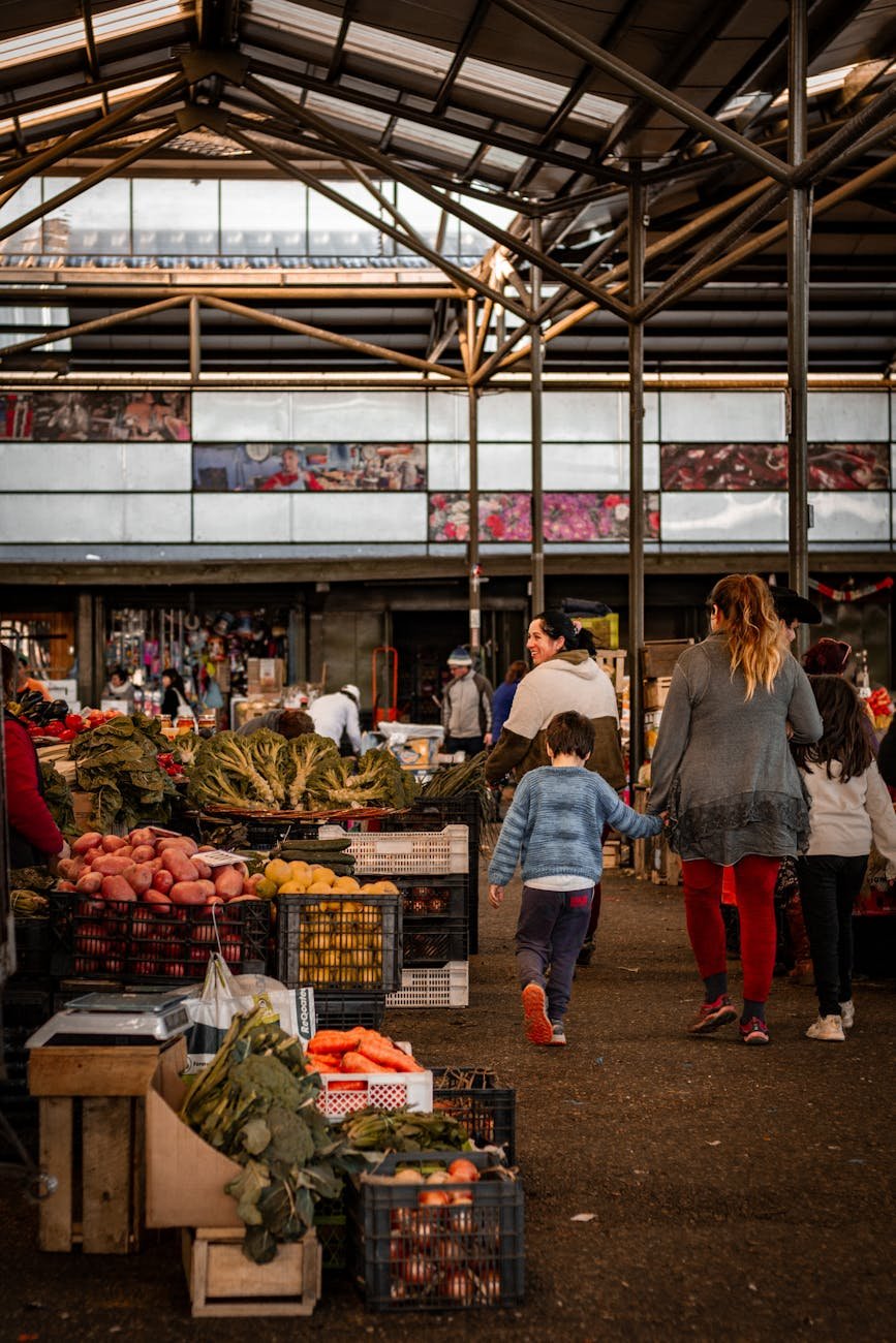 mãe caminhando com crianças no bazar