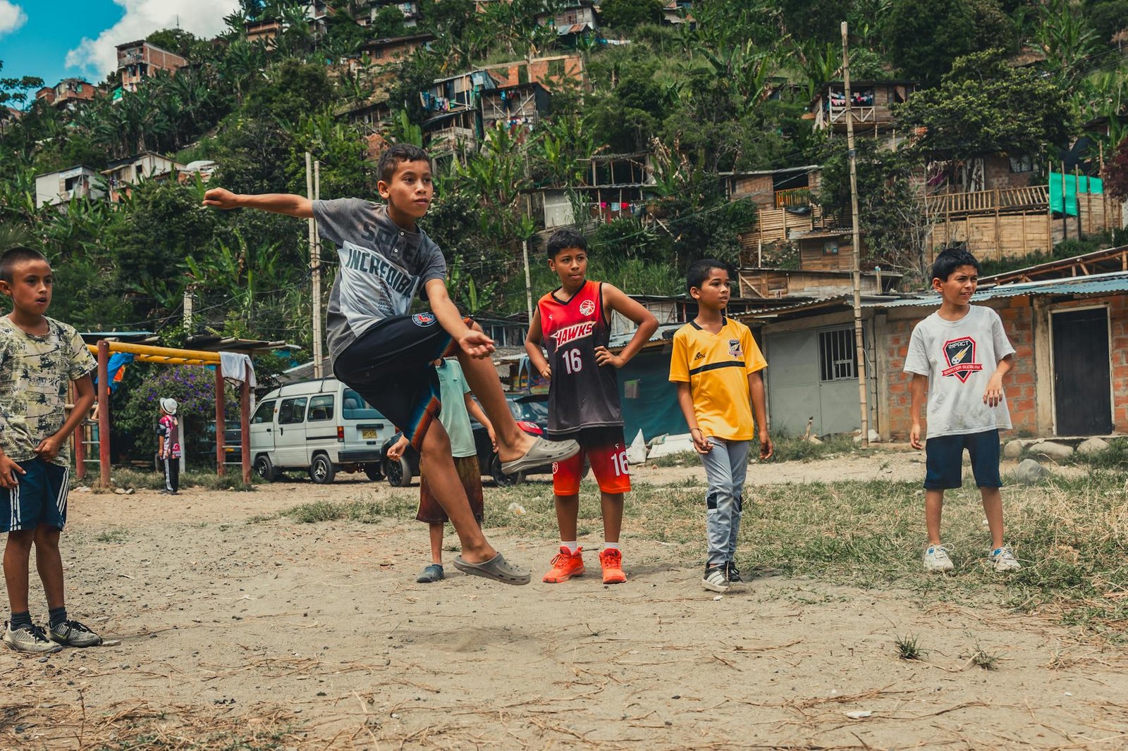 crianças enérgicas jogando futebol em ambiente rural