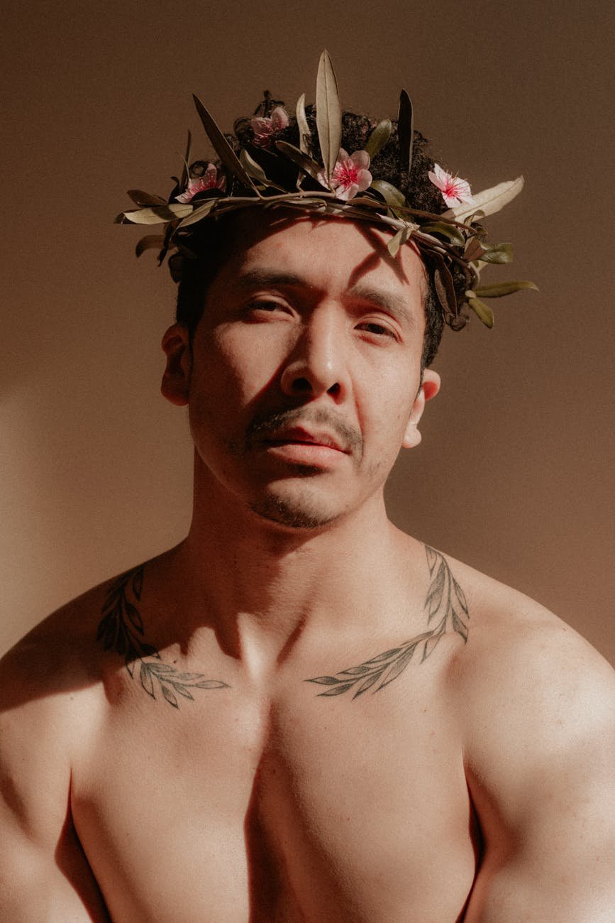 retrato artístico de um homem tatuado com coroa de flores