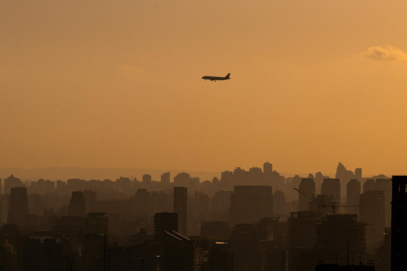 avião sobrevoando são paulo ao pôr do sol