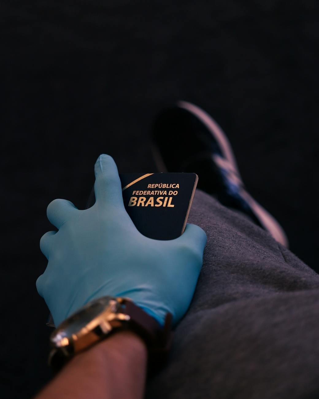 mão humana enluvada segurando passaporte