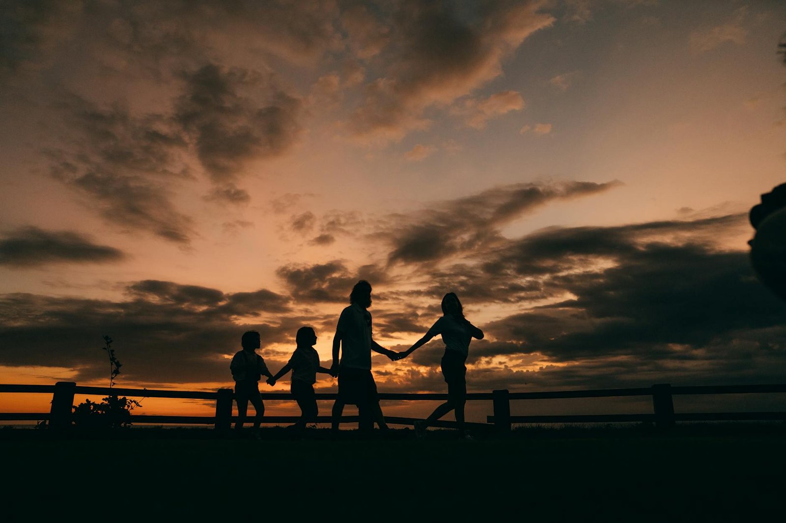 uma silhueta de uma família caminhando de mãos dadas