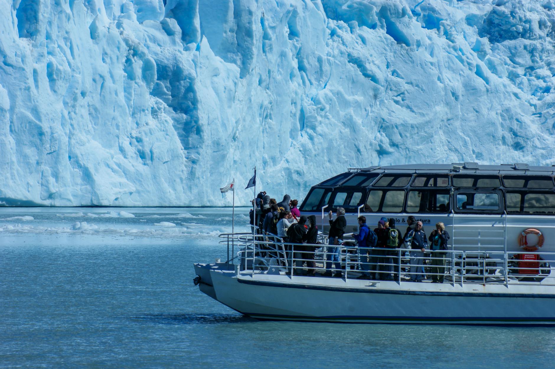 pessoas andando em um barco branco e azul no mar
