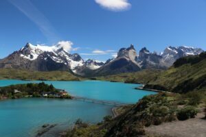 um lago cercado por montanhas e uma ponte