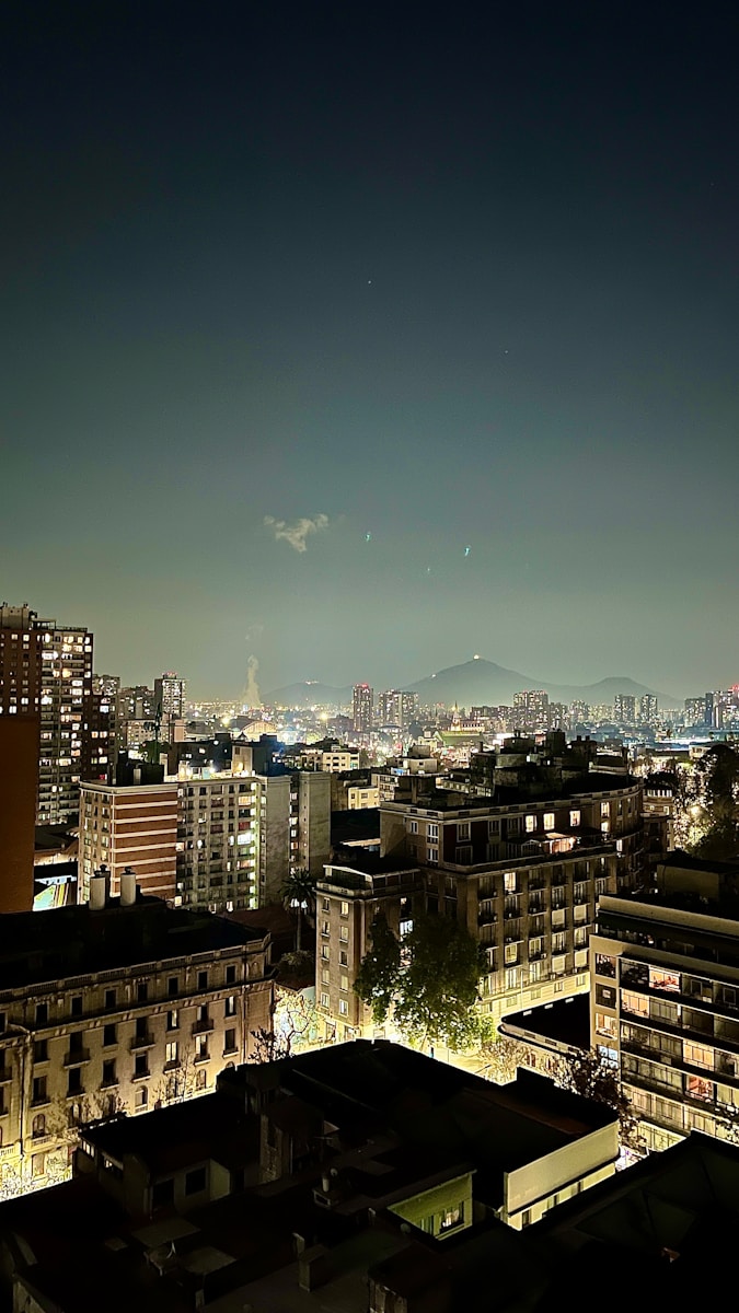Uma vista de uma cidade à noite do topo de um edifício