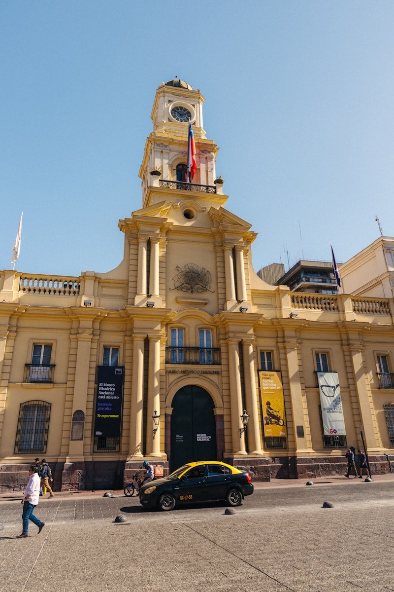 um grande edifício amarelo com uma torre do relógio