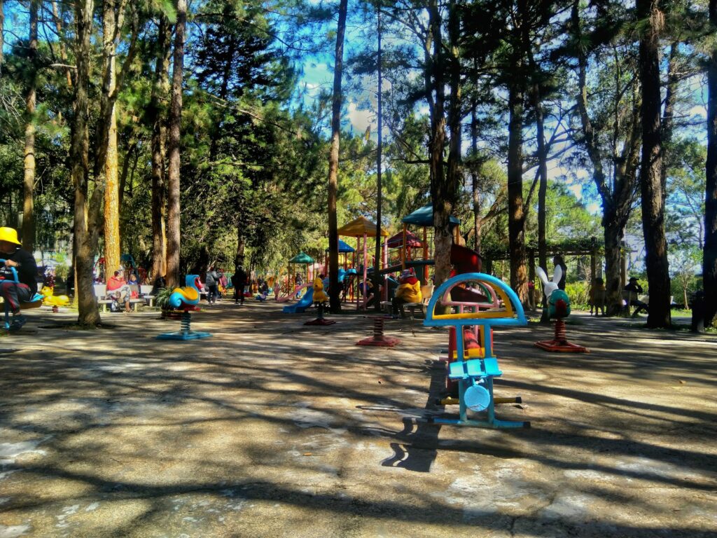 um parque com vários brinquedos infantis e árvores