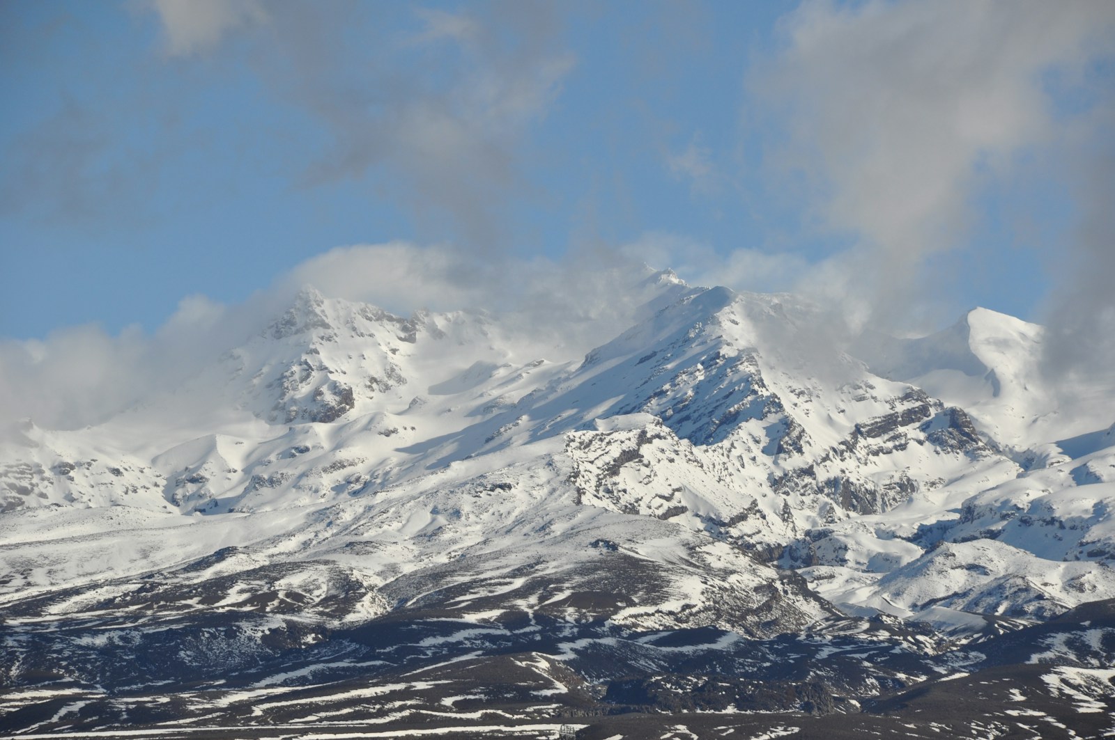 montanha coberta de neve sob céu azul durante o dia
