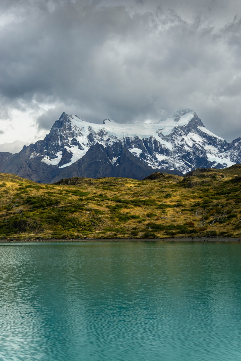 Montanhas cobertas de neve refletem no lago azul-turquesa.