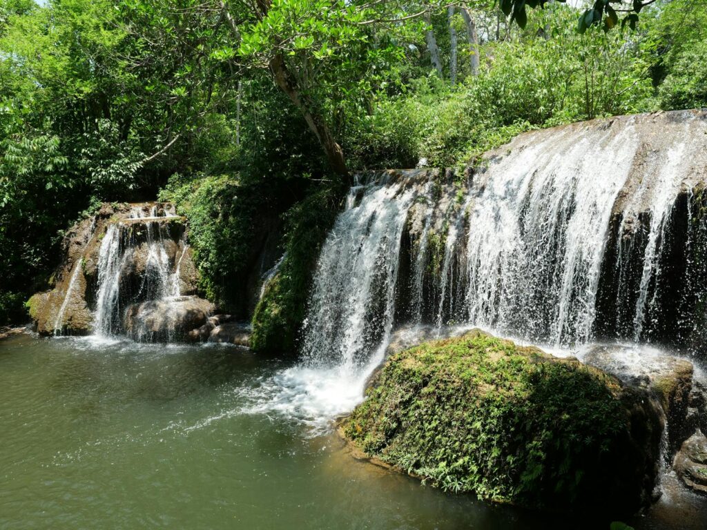 Cachoeiras de águas verdes cristalinas cercadas por floresta densa em Bonito, MS.