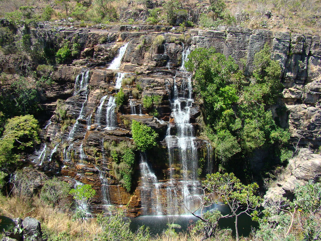 Vista frontal da Cachoeira dos Couros na Chapada dos Veadeiros com múltiplas quedas d'água em paredão rochoso.