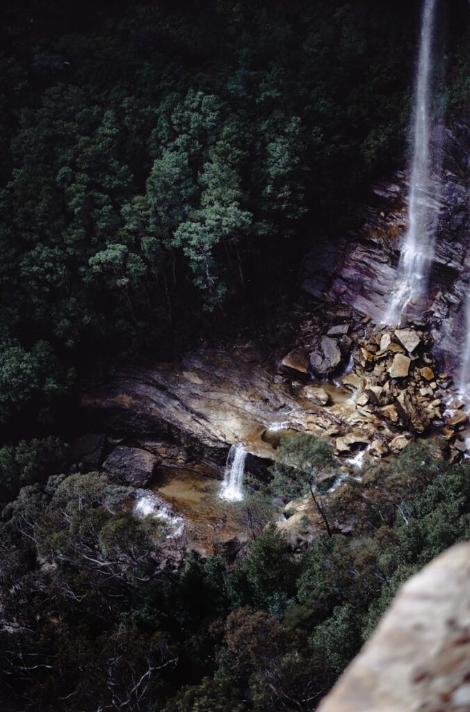 Cachoeira alta descendo por paredão de pedra no Itatiaia, opção de montanhismo nos destinos de aventura Brasil.