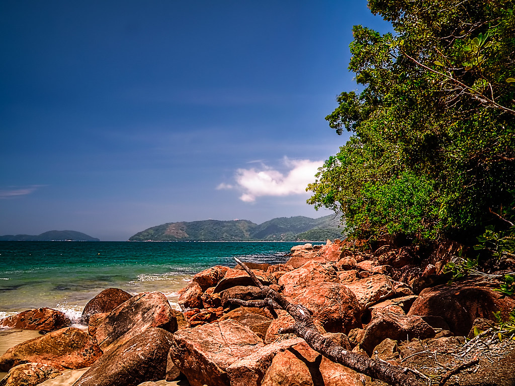 Canto de praia em Ubatuba com rochas, vegetação nativa e mar cristalino, ideal para exploração em família.