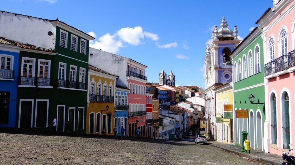 Ladeira de paralelepípedos no Pelourinho, Salvador, cercada por casarões coloniais coloridos e igrejas ao fundo.