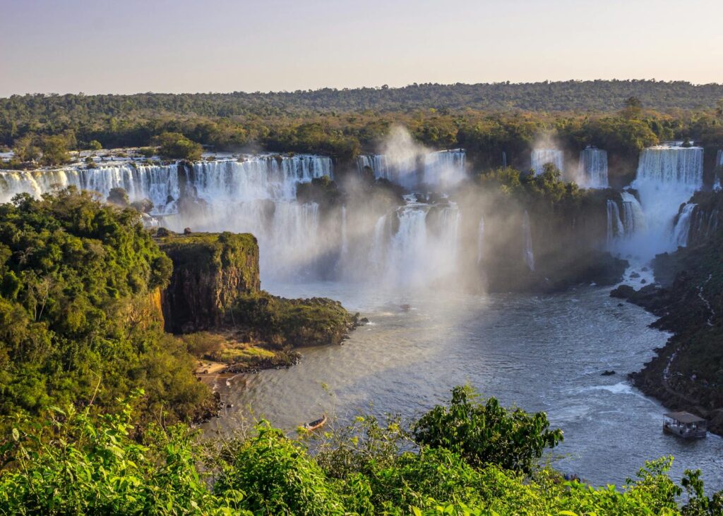 Vista panorâmica das Cataratas do Iguaçu em Foz do Iguaçu, com quedas d'água volumosas e arco-íris.