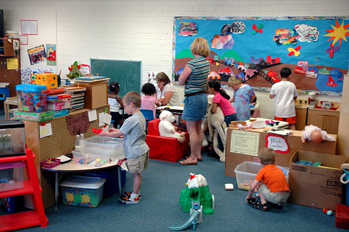 grupo de crianças pequenas brincando e interagindo em uma sala de atividades lúdicas