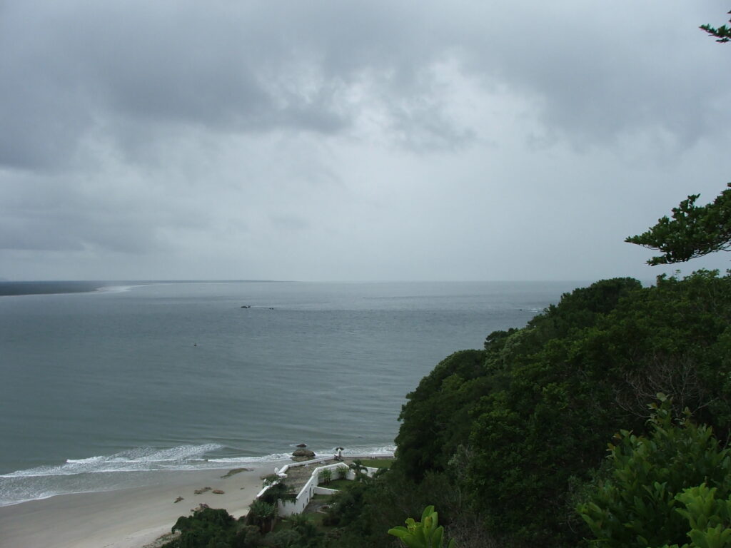 Vista panorâmica do alto mostrando o litoral e a vegetação preservada da Ilha do Mel, destino de turismo ecológico no Brasil, no Paraná.