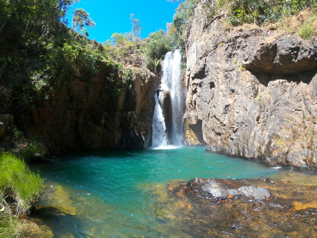 bela cachoeira com queda d'água branca e piscina natural de água azul turquesa