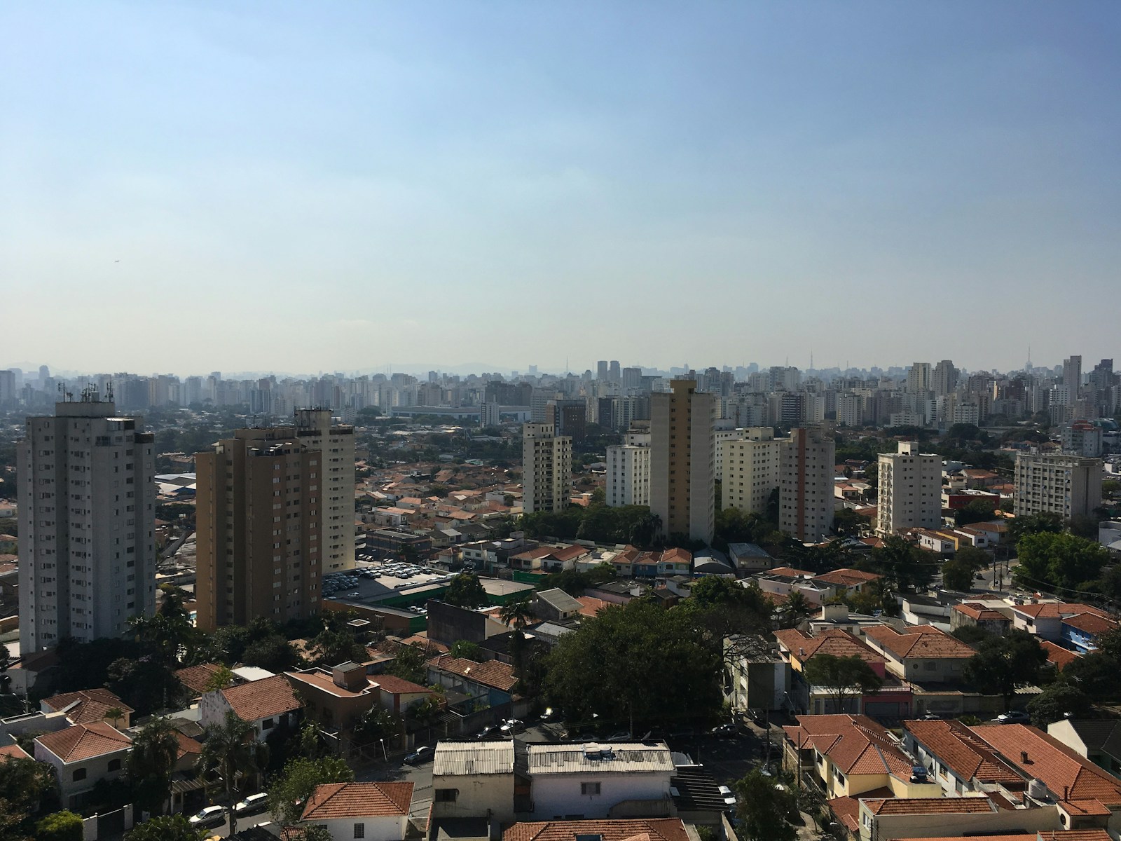 Vista aérea urbana de São Paulo com prédios residenciais e céu azul.